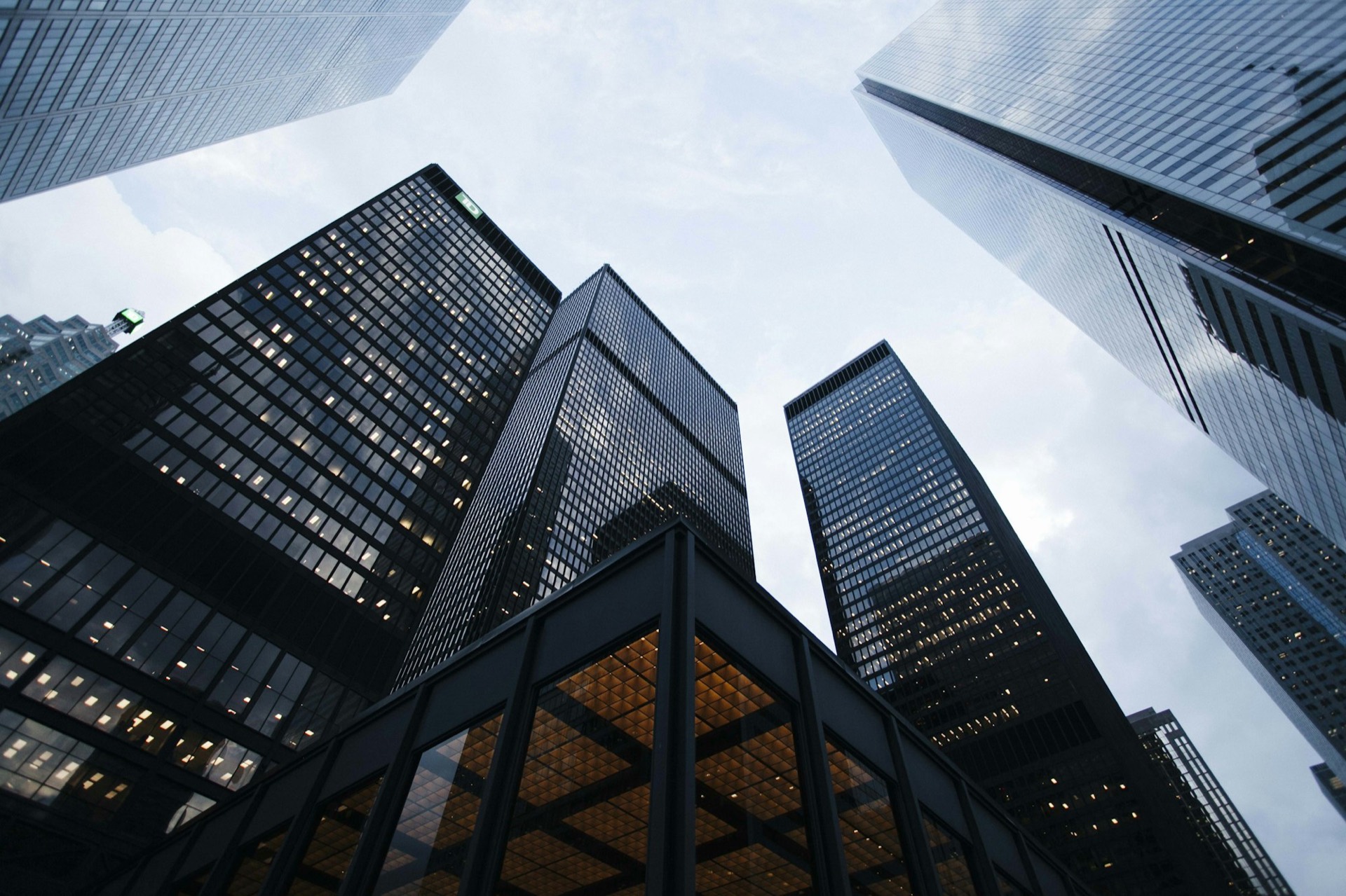 Dark glass towers seen from below, reflecting afternoon sun load