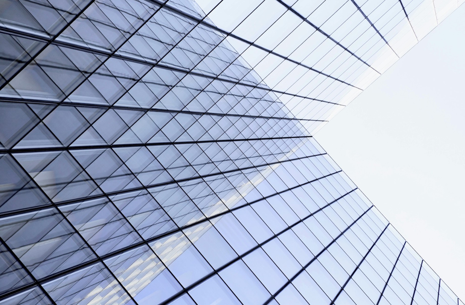 Reflective glass skyscraper mirroring a cloudscape